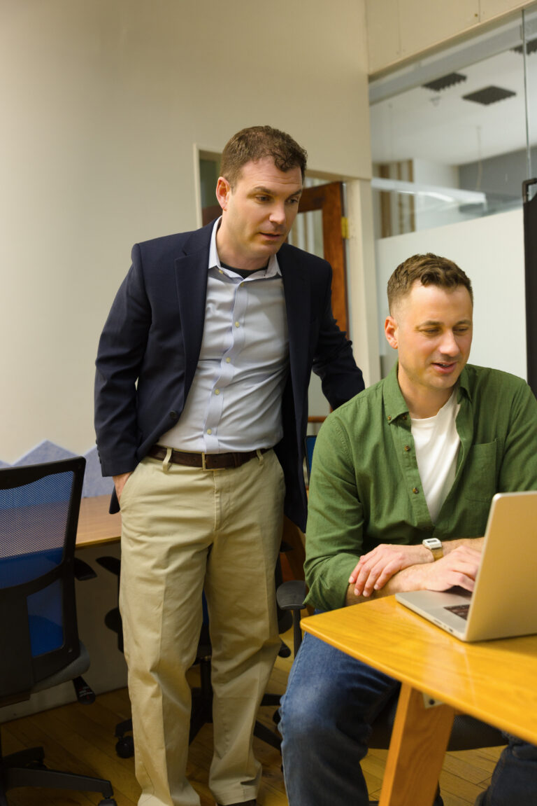 Two professionals collaborate on a laptop in a modern Philadelphia office.